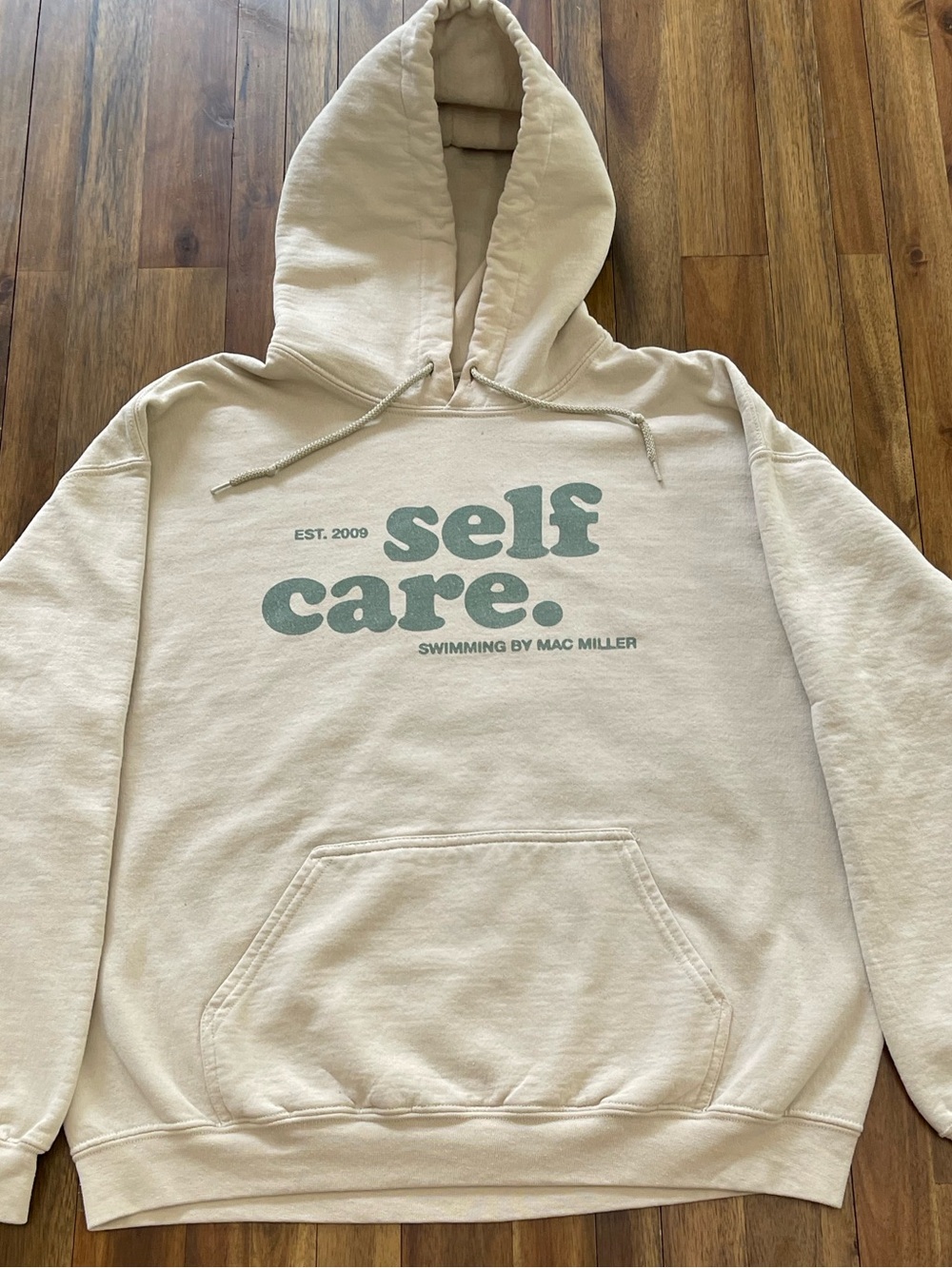 Mac Miller Self Care Gildan Cream Hoodie with Green Lettering.